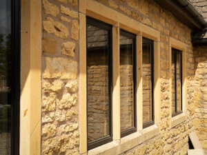 Aluminium heritage window upgrade in Cotswold stone mullions