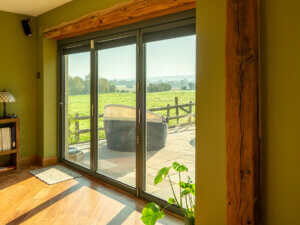 Outward opening Lacuna bifold door with aftermarket internal blinds painted RAL 7012 Basalt Grey