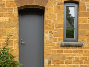 Rationel Slate Grey Panel Door with vertical grooves and a sidehung window